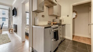 A modern kitchen with a built-in stove, microwave, and stainless steel cabinets. - 1 Bed in Tenby (oc-t36054) (Tenby)