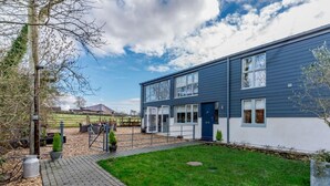 Een modern herenhuis met een geplaveid oprit en een verzorgd gazon.