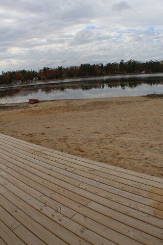 Relax at a newly restored lakefront home with a sandy beach and calm waters.