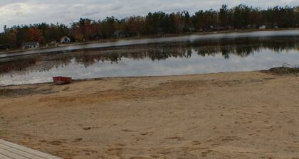 Relax at a newly restored lakefront home with a sandy beach and calm waters.
