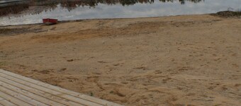 Relax at a newly restored lakefront home with a sandy beach and calm waters.