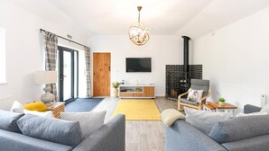 Uma sala de estar moderna com lareira, sofá, TV e uma porta de madeira.