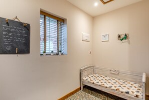 A small room with a bed, a window with blinds, a chalkboard with a welcome message, and a small table with a plant. - 2 Bed in Belchford (oc-o36036) (Belchford)