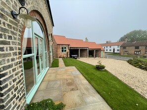 A residential property with a stone facade, a covered garage, and a well-maintained lawn. - 2 Bed in Belchford (oc-o36036) (Belchford)