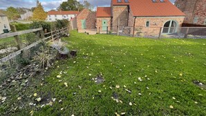 A brick house with a red-tiled roof, a fenced yard, and a green door. - 2 Bed in Belchford (oc-o36036) (Belchford)