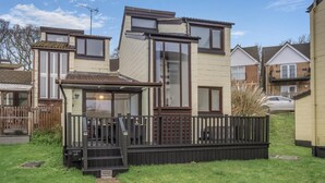 Ein Wohnhaus mit einer Terrasse, einer kleinen Veranda und einem Weg zum Eingang.