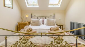 A bedroom with a bed, two bedside tables, a radiator, and a skylight. - 1 Bed in Picklescott (oc-o35147) (Ratlinghope)