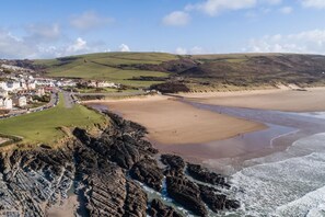 A coastal town with a sandy beach, rocky coastline, and a residential area with houses. - 4 Bed in Mortehoe (oc-d35057) (Mortehoe)