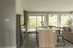 Een moderne keuken met een centraal eiland, een inbouwoven en een koelkast.