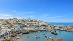 A coastal town with colorful buildings, a harbor with boats, and a clear blue sky. - 4 Bed in Brixham (oc-t35056) (Brixham)