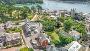 Une ville côtière dotée d’un clocher d’église imposant, d’un port de plaisance avec des bateaux et d’immeubles résidentiels.