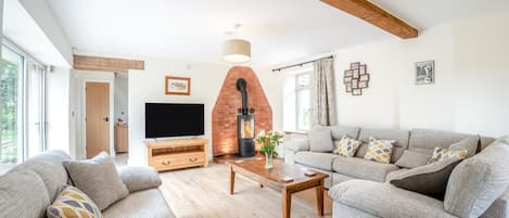 A living room with a fireplace, a sofa set, a TV, and a wooden coffee table.