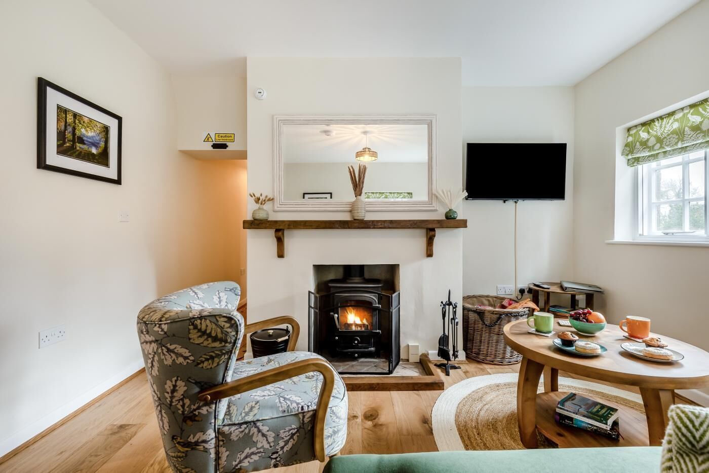 Una sala de estar acogedora con chimenea, televisor y comedor con mesa dispuesta para una comida.
