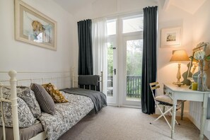 A bedroom with a bed, a desk, a chair, and a balcony. - 3 Bed in Ellwood (oc-t35963) (Ellwood)