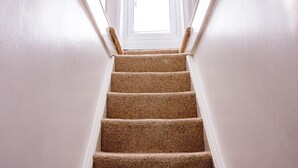 A carpeted staircase with white walls and a door at the top. - 2 Bed in Shaldon (oc-t36353) (Shaldon)