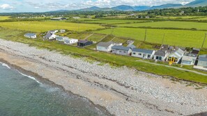 A coastal property with a beach, houses, and fields. - Beach Bungalow - sleeps 6 guests  in 3 bedrooms (Nefyn)