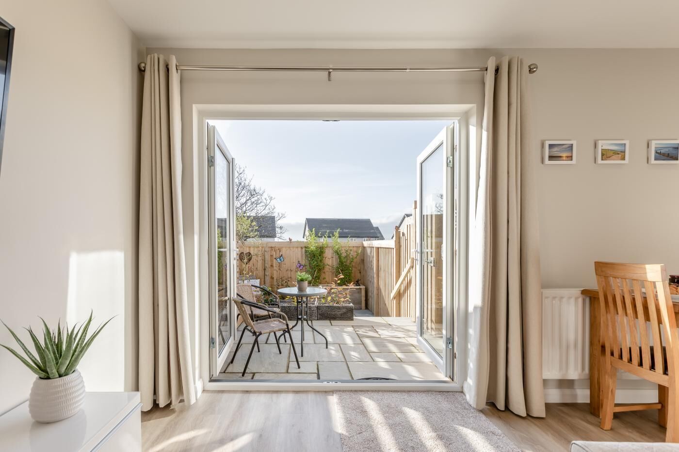 A modern room with a sliding glass door leading to an outdoor patio with a table and chairs.