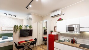 A compact kitchen with a microwave, sink, and red refrigerator. - Red Hat Home by Campo de Fiori (Rome)