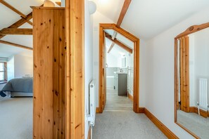 A room with a wooden door, a radiator, and a view into a kitchen area. - 3 Bed in Parkmill (oc-t36335) (Parkmill)