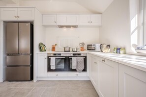 A modern kitchen with white cabinetry, a stainless steel refrigerator, double ovens, and a microwave. - 3 Bed in Berwick St. John (oc-k36615) (Berwick Saint John)