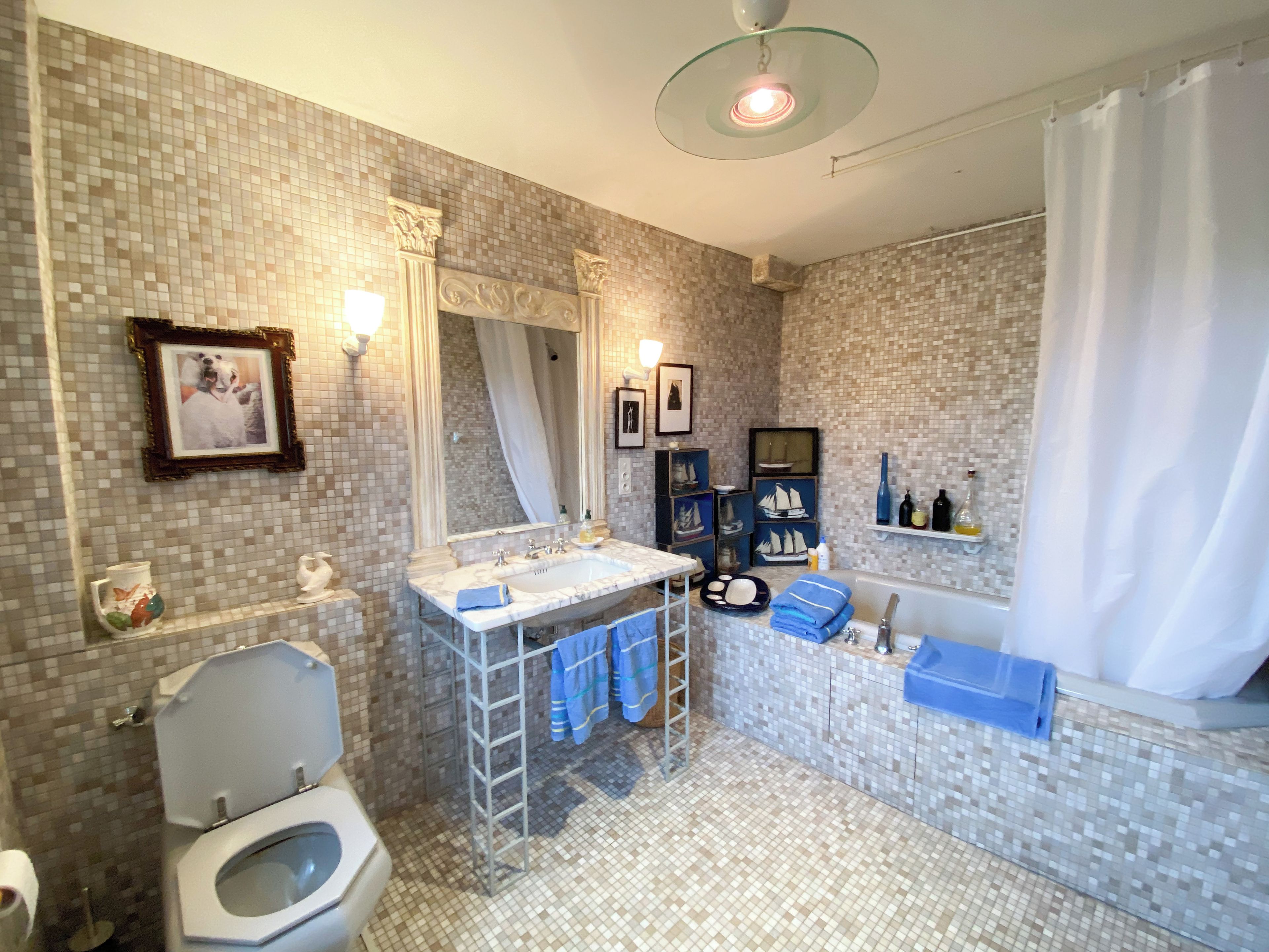 Une salle de bain équipée de toilettes, d’un lavabo, d’une baignoire et d’un rideau de douche.
