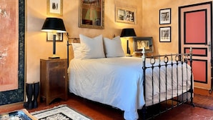 A bedroom with a bed, two bedside lamps, a nightstand, a dresser, and a door. - La Maison des Chapitres (FORCALQUIER)
