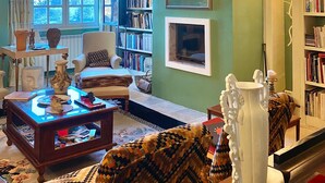 A cozy living room with a fireplace, a bookshelf, and a comfortable seating area. - La Maison des Chapitres (FORCALQUIER)