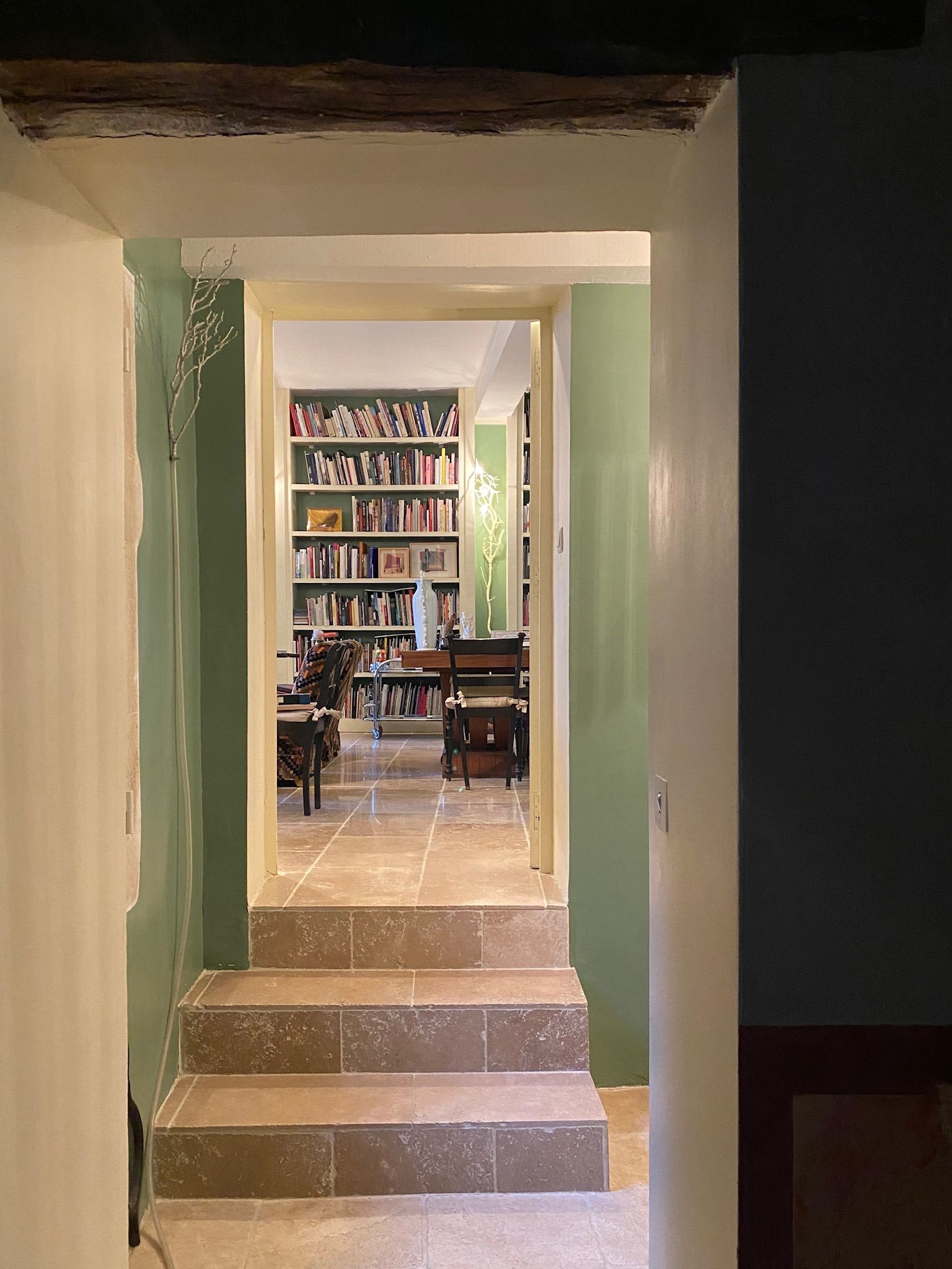 Un escalier menant à une pièce où se trouve une bibliothèque remplie de livres.