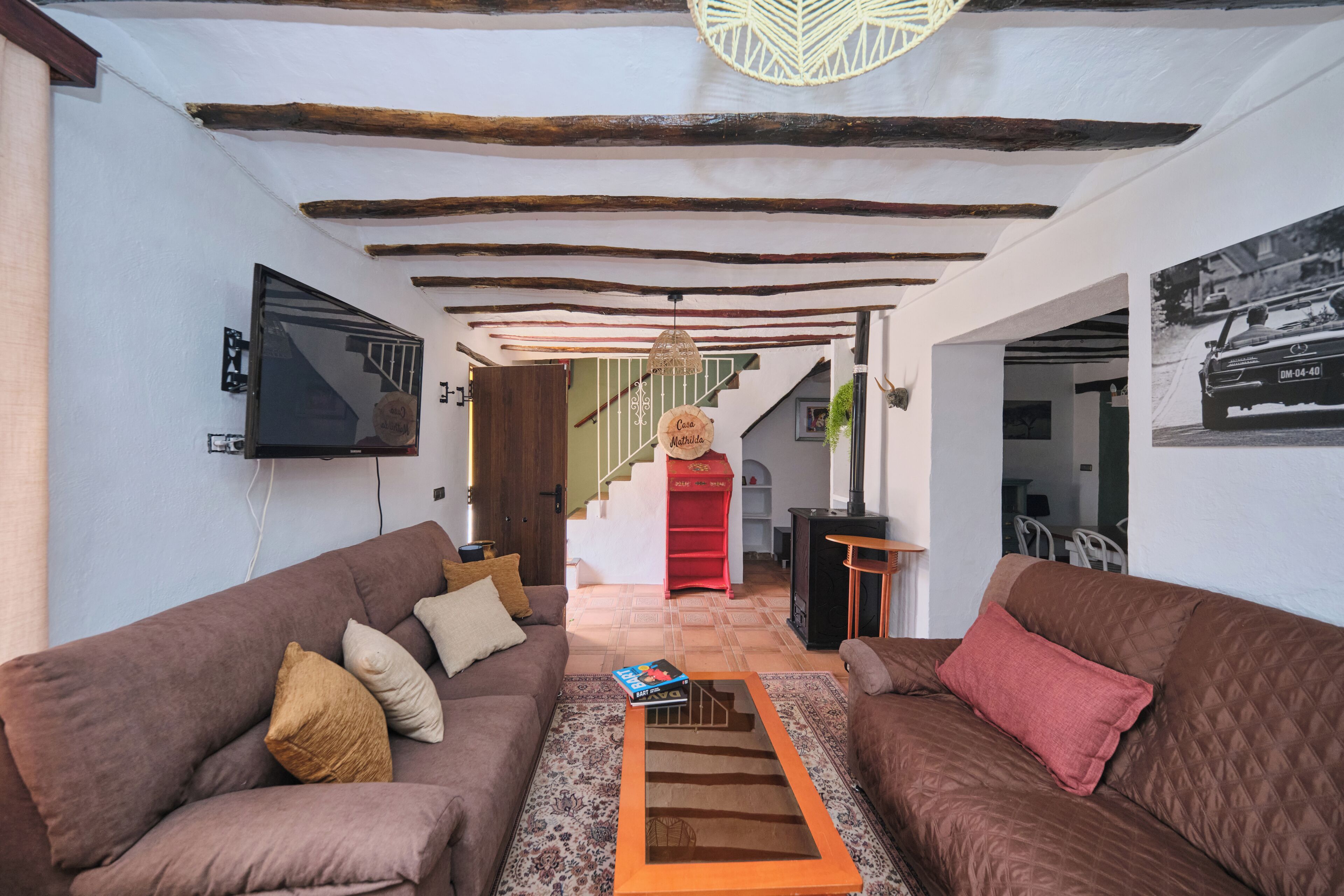 A living room with a sofa, a coffee table, and a staircase leading to an upper floor.