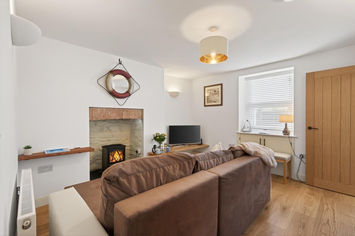 A modern living room with a fireplace, a sofa, a TV, and a wooden door.