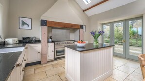 A kitchen with a central island, a built-in oven, a stove, and a large window. - 2 Bed in Christon Bank (oc-coq128) (Christon Bank)