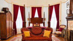 Un dormitorio con una cama con dosel, un armario de madera, un sofá y una mesa.