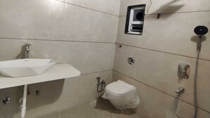A bathroom with a white sink, toilet, and shower. - Palette Hotel and Resort Pandharpur (Pandharpur)
