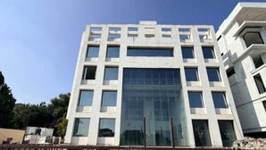 A modern building with a symmetrical facade, multiple windows, and a central glass section. - Palette Hotel and Resort Pandharpur (Pandharpur)