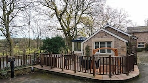 A stone cottage with a wooden deck and a metal fence. - 2 Bed in Crook O Lune (oc-h36291) (Halton)