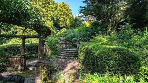 A stone staircase leading up to a covered area, surrounded by lush greenery and trees. - 2 Bed in Crook O Lune (oc-h36291) (Halton)
