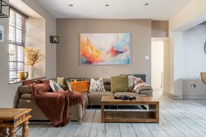 Ein Wohnzimmer mit einer Couch, einem Couchtisch und einem großen abstrakten Gemälde an der Wand.