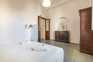 A hotel room with a bed, a dresser, a mirror, and a wardrobe. - Corso View Apartment (Cagliari)
