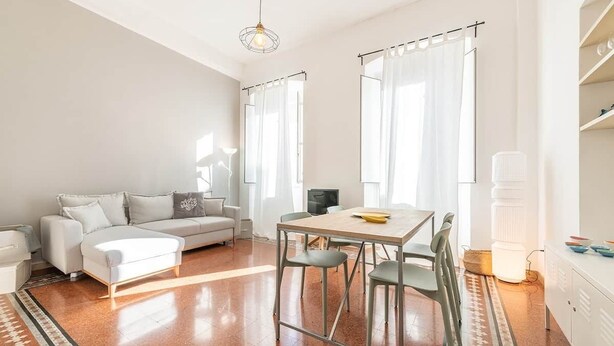 Een moderne woonkamer met een bank, een eettafel en stoelen.