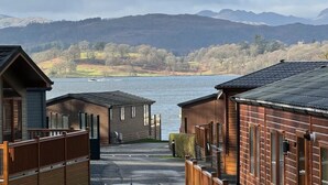 A row of cabins with a view of a lake and mountains in the background. - 2 Bed in Troutbeck Bridge (oc-p36885) (Troutbeck Bridge)