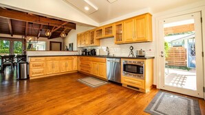 A modern kitchen with wooden cabinets, stainless steel appliances, and a large island.