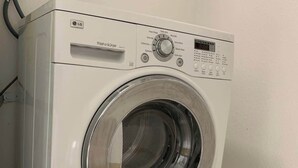 A white LG washer and dryer with a control panel, a digital display, and a stainless steel door.