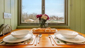 A dining table with two white bowls, a plate of rolls, and a vase with flowers. - 1 Bed in Marden (oc-c34994) (Horsmonden)