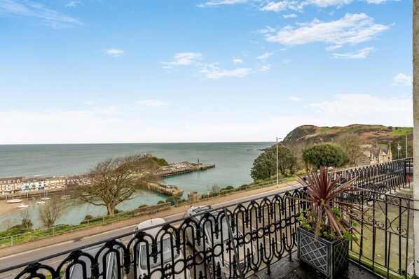 A coastal view with a promenade, a pier, and a hill in the background. - 3 Bed in Ilfracombe (oc-h36896) (Ilfracombe)