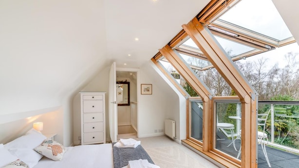 A bedroom with a skylight, a bed, a dresser, and a view of the outdoors. - 4 Bed in Beckley (oc-s34808) (Beckley)