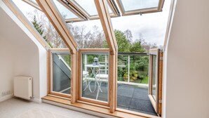 A modern room with skylights, a radiator, and a view of a garden. - 4 Bed in Beckley (oc-s34808) (Beckley)
