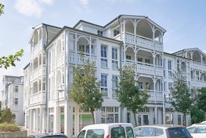 Un edificio de varios pisos con balcones, un garaje y un letrero que indica un restaurante.