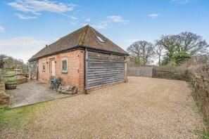 Un bâtiment en briques doté d’un toit en pente et d’une grande porte en bois.