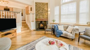 A living room with a fireplace, a television, and a staircase. - 3 Bed in Dunning (oc-t35973) (Dunning)