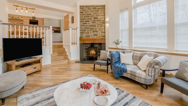 A modern living room with a fireplace, a television, and a sofa. - 3 Bed in Dunning (oc-t35973) (Dunning)